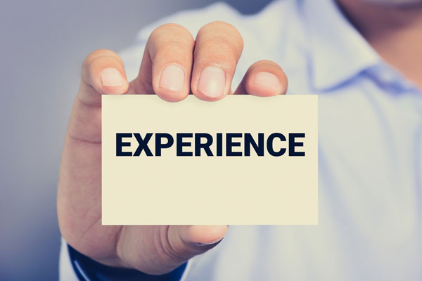 Businessman holding note with the word experience in his hand.