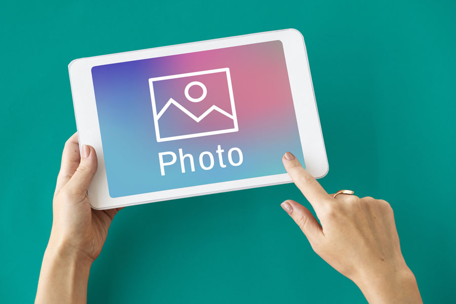 Hands on computer tablet with photo text and image on screen.
