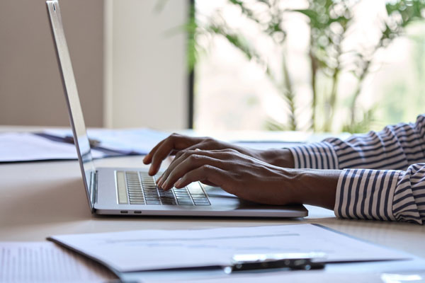 Hands writing home care value proposition on laptop.