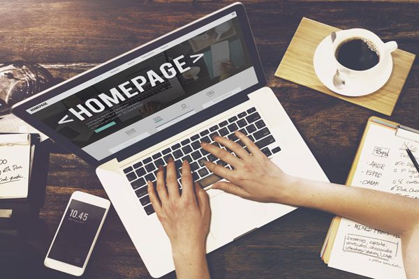 Hands typing on laptop open to homepage.