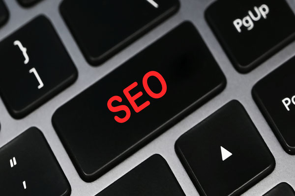Red word SEO on grey keyboard key.
